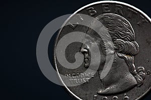 Man's hand holding a silver American coin, close-up of a quarter dollar coin isolated over black. Bag, dollars