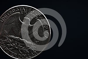 Man's hand holding a silver American coin, close-up of a quarter dollar coin isolated over black. Bag, dollars