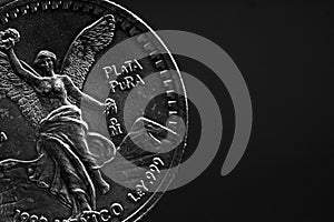 Man's hand holding a silver American coin, close-up of a quarter dollar coin isolated over black. Bag, dollars