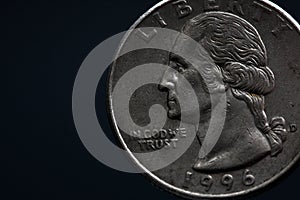 Man's hand holding a silver American coin, close-up of a quarter dollar coin isolated over black. Bag, dollars