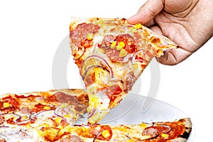 Man`s hand holding a slice of salami and sweetcorn pizza. White