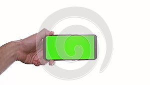 man's hand holding a smartphone with a vertical green screen