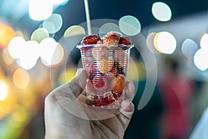 Man`s hand holding Strawberry cone