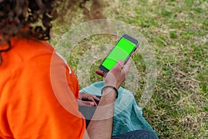 Man`s hand holding and using mobile smart phone on nature