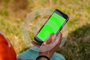 Man's hand holding and using mobile smart phone on nature