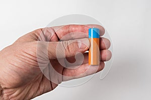 Man`s hand holds a AA battery. Accumulator on white background photo