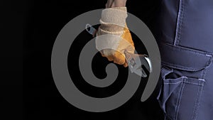 A man& x27;s hand holds an adjustable wrench on a black background. Place to place text.