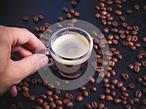 a man`s hand holds a Cup of espresso against a background