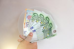 The man`s hand holds the 100 euro, considers them and pays. Pape