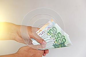 The man`s hand holds the 100 euro, considers them and pays. Pape