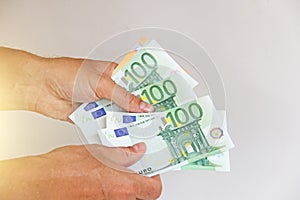 The man`s hand holds the 100 euro, considers them and pays. Pape