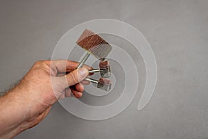 A man`s hand holds the Grinding Blade Wheels. A tool for woodworking as well as stripping surfaces of corrosion, scale or rust.