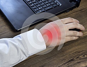 A man`s hand holds a mouse while working at a computer, a pain in his hand, a close-up