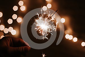 Man`s hand holds sparklers, Happy New Year photo