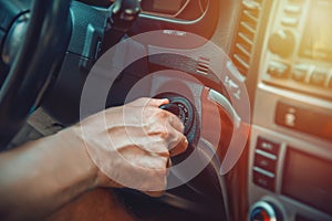 Man`s hand on ignition key about to start an suv