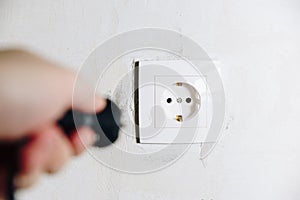 The man`s hand inserts the plug from the socket
