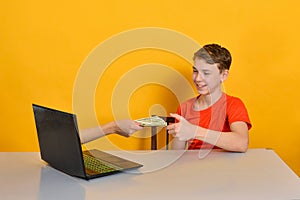 A man hand from a laptop monitor holds out dollars to the user. Online earnings concept