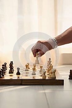 Man`s hand moving a chess piece. Conceptual image