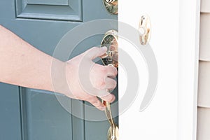 Man's hand opening front door photo