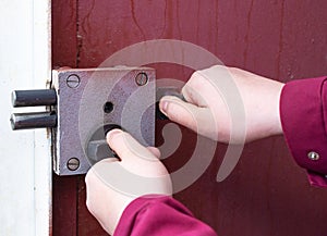 A man`s hand opens the lock on the front iron door from the street.