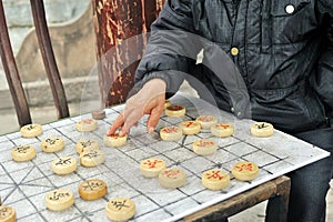 Man`s hand plays Xiangqi, known as Chinese chess game board, an ancient board game of traditional China