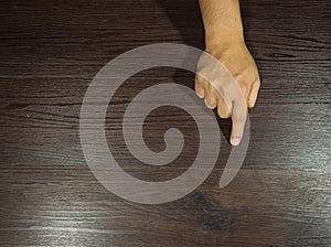 The man`s hand is pointing something on the brown wooden floor scene. There is space for copy space