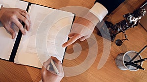 Man`s hand points with finger where to put signature on document. Signing contract on divorce.