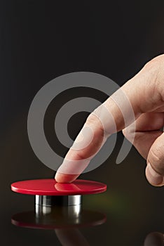 A man& x27;s hand presses a big red button. Red button on a dark background. The threat of using nuclear or chemical