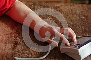 A man`s hand presses the button of the digital blood pressure mo