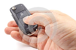 Man`s hand presses button on the ignition key