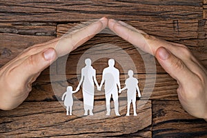 Man`s Hand Protecting The White Cutout Family Paper