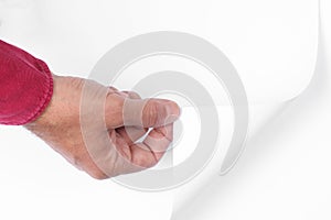 Man`s hand pull up  a bottom corner of a white paper sheet to uncover a neutral foreground with clipping path and copy space for