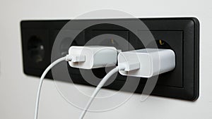 Man's hand pulling out the plugs from the sockets after powering the electronic devices