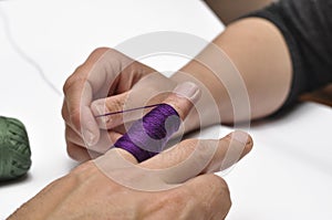 Man& x27;s hand and purple yarn isolated on a white background.Crochet.Copy space