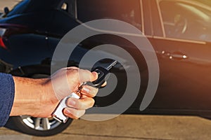 Man`s hand pushing button on remote control car key