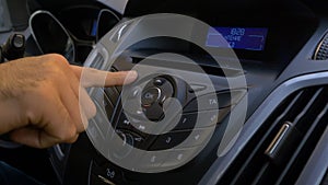 Man`s hand puts the disk into the car player. Button control for compact disk player in a car. Hand puts the disk into