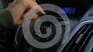 Man`s hand puts the disk into the car player. Button control for compact disk player in a car. Hand puts the disk into