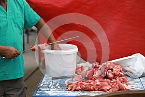 A man& x27;s hand puts meat on a skewer. Preparation of shish kebab. Shish kebab on skewers.