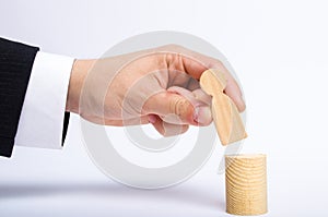 A man`s hand puts a person`s figure on top of his new post. A businessman appoints a person to a managerial position. photo