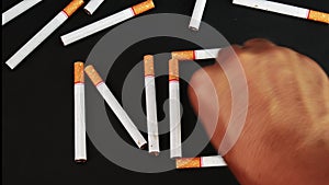 Man`s hand putting out a cigarette on dark background. Stop smoking. World no tobacco day.