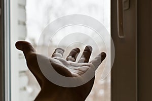 Man`s hand reaches for  window. Concept: asking for help, depression, finding way out, freedom, sharing your feelings. Hand