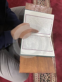 A man\'s hand reading the Koran