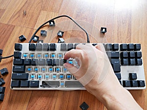 Man& x27;s hand remove each keycap and cleaning mechanical keyboard