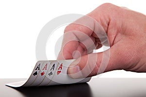 Man's hand revealing four aces