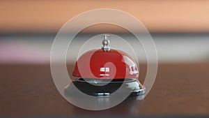 A man`s hand rings the bell at the front desk, close-up, blurred neutral background, selective focus. Concept: Call the receptioni