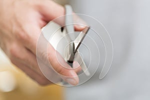 Man's hand with scissors on a background.