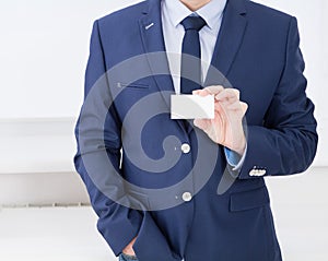 Man`s hand showing business card - closeup shot in office, blank, top view