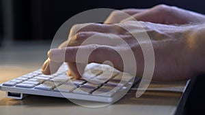 Man`s hand with smart watch close up type at desktop keyboard in workspace. Young businessman are working with pleasure