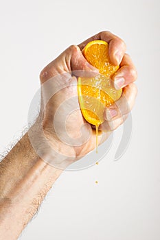 Man's Hand Squeezing an Orange Half
