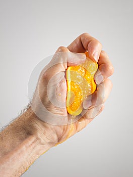 Man's Hand Squeezing an Orange Half